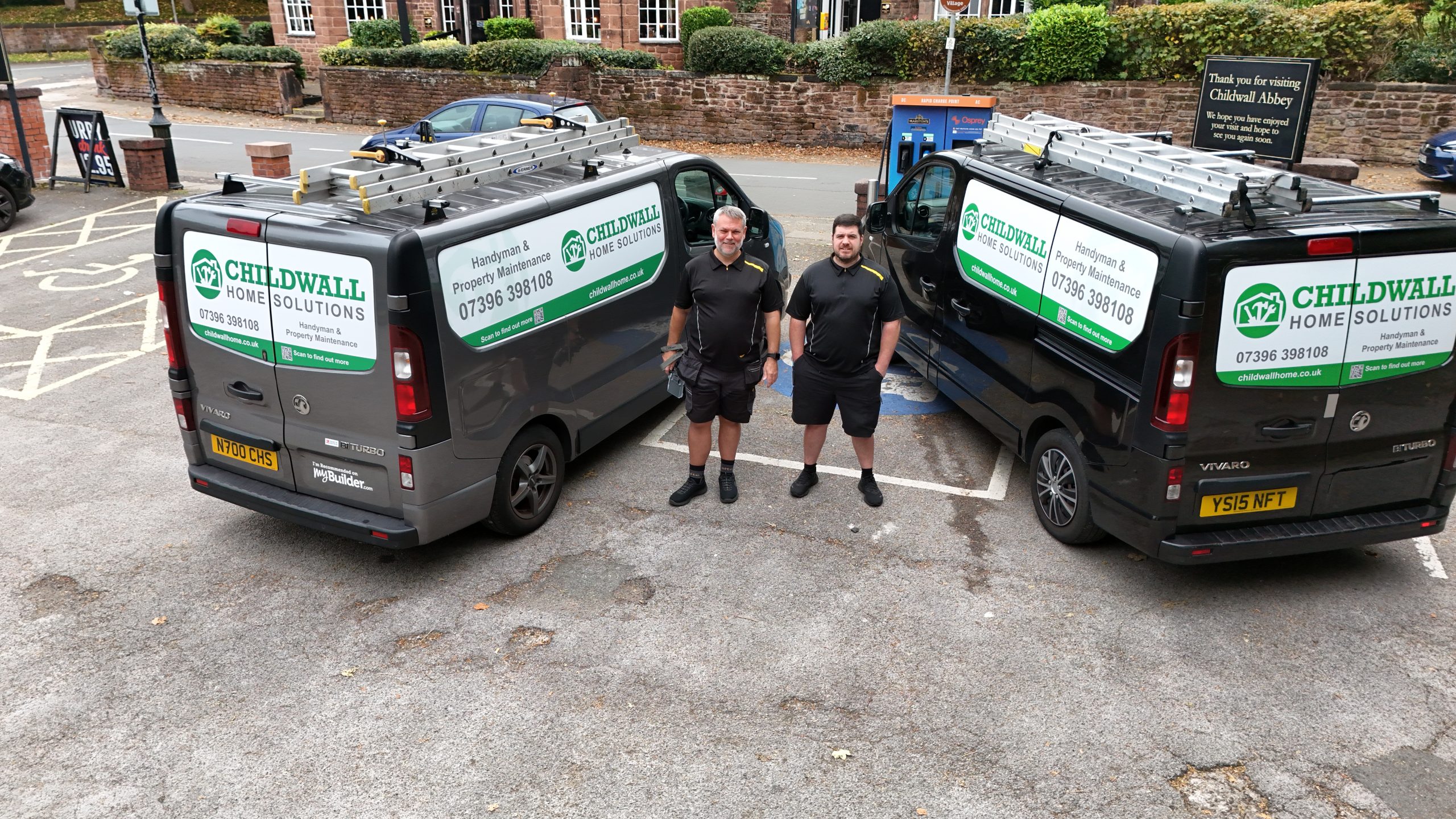 two men standing by two vans
